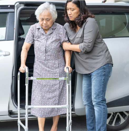 cuidadora ayudando a adulto mayor a movilizarse